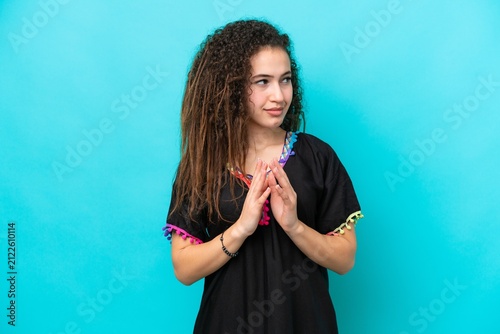 Young Arab woman isolated on blue background scheming something