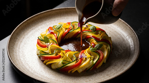 A beautifully detailed photorealistic stock photograph capturing an avant-garde deconstructed ratatouille with perfectly rolled zucchini ribbons and rich tomato essence.