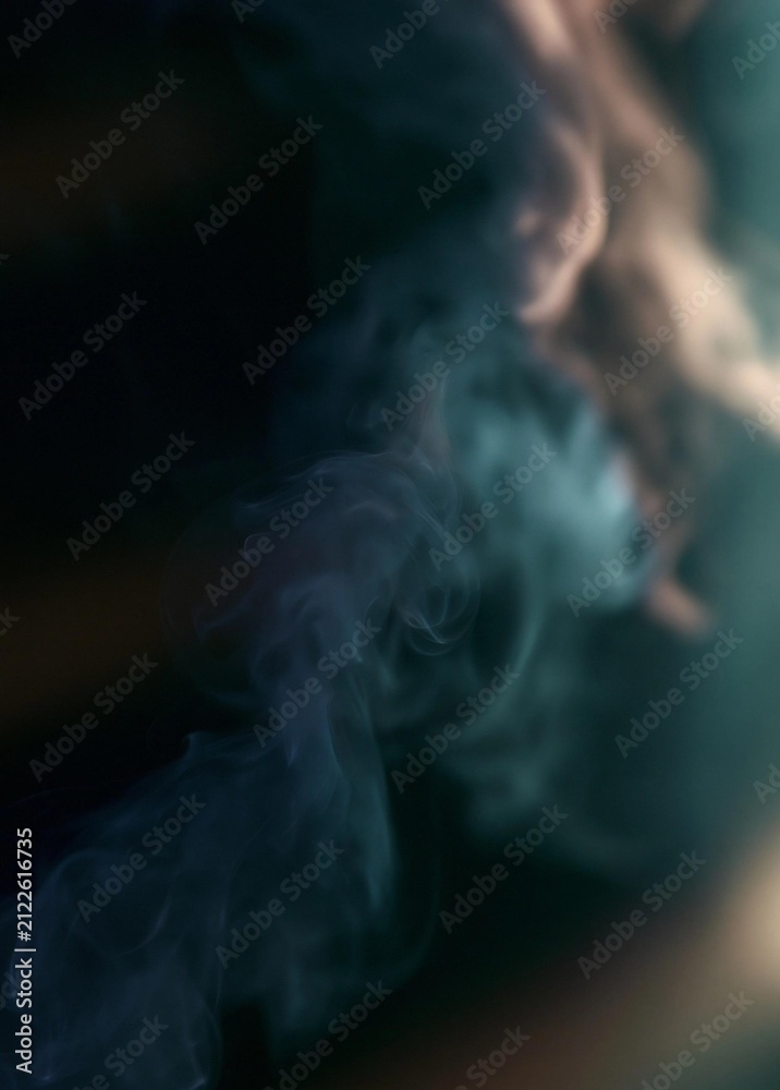 Fototapeta premium Close-up of a cloud of smoke. the smoke is dark blue in color and appears to be billowing upwards. the background is blurred, making the smoke the focal point of the image.