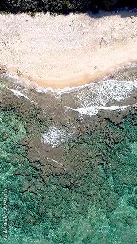 Vertical loopable top down aerial view of a Sardinian beach with turquoise sea, white sand and Mediterranean coastal landscape creating a seamless travel background.