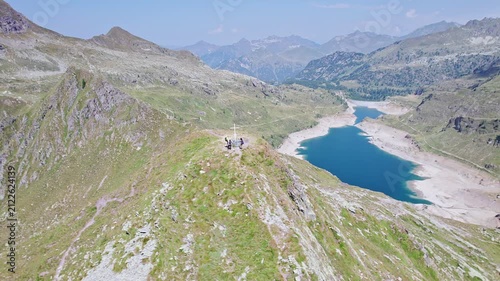 Hikers on top of mountain peak with Twin lakes on background, Orobie mountains, Lombardy landscape
