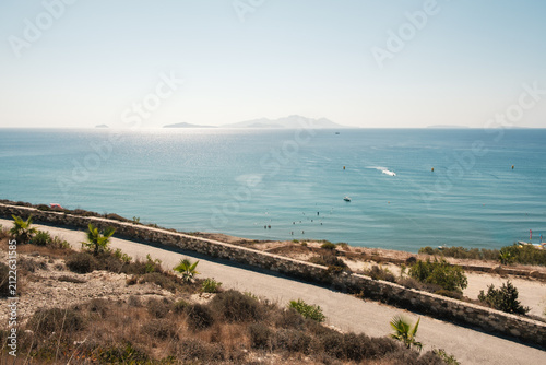 Sunny day at beach on the Greek island of Kos, with mountains in the background.
