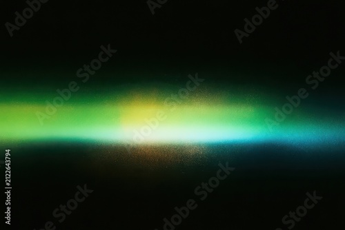Abstract horizontal light streak with grainy texture in green and blue