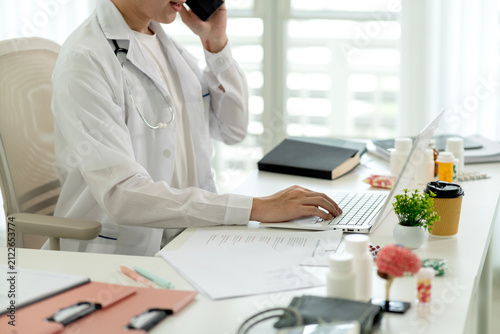 Professional Doctor Consulting Patient via Telemedicine Video Call Using Laptop at Modern Clinic Office