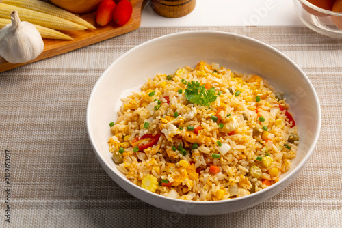 Thai Fried rice with egg ,green pea ,carrot ,corn and tomato in white plate.