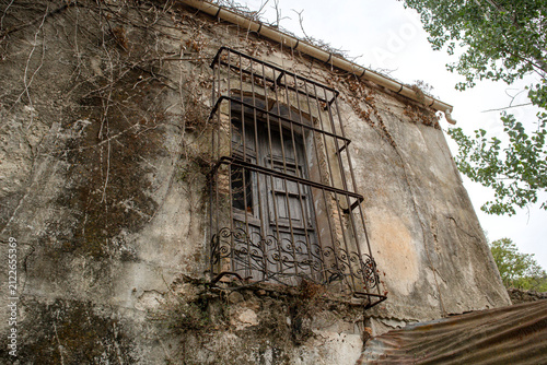 Obraz na płótnie Vintage wooden shutter window in a rusted iron cage on a Spanish building surrou