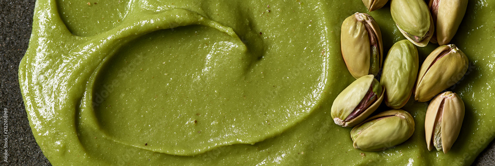 Fototapeta premium pistachio kernels and cream texture closeup, luxury pistachio cream and nut texture macro composition, premium green pistachio ingredient texture with smooth cream