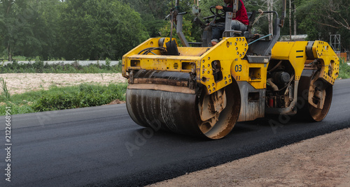 Quadro su tela Asphalt road roller with heavy vibration roller compactor press new hot asphalt on the roadway on a road construction site