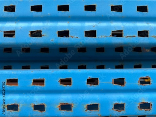 Close-up of rusty blue perforated metal surface