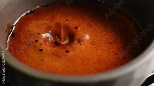 Fresh roasted coffee beans and rich espresso extraction with golden crema swirling in ceramic cup
