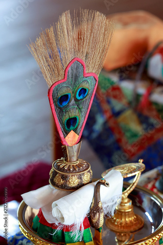 Bild auf Leinwand Vajrayāna ritual table: the peacock-feather flywhisk sits at the center of the gilded tray, surrounded by the divination mirror, the drilbu, the vajra, and Tibetan sacred texts