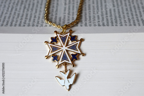 Bild auf Leinwand A Protestant Huguenot cross pendant in blue enamel resting on an open Bible