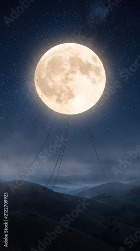 Super realistic detailed high quality photo - giant glowing full moon floating in the night sky like a hot air balloon above the hills held by thin ropes 