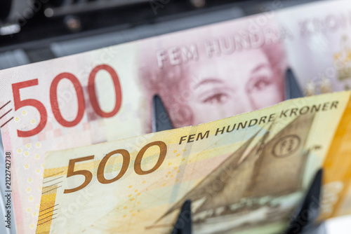 Foto Norwegian Krone versus Swedish Krona banknotes inside currency counter machine
