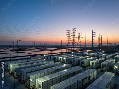 Energy storage power station at dusk with equipment arrays and transmission towers