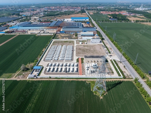 Aerial view of a photovoltaic power station adjacent to farmland and industrial zones