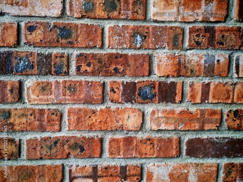 Quadro su tela Front view of an aged red brick wall featuring natural wear, mortar lines, and rough texture suitable for construction and architectural backgrounds