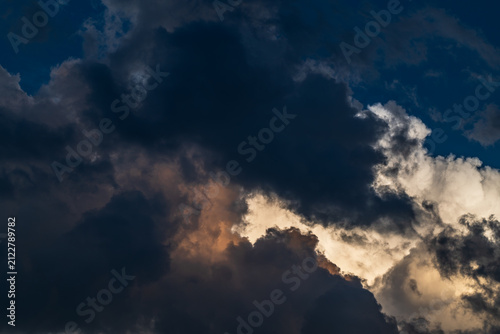 Cloudscape with dark and dramatic clouds at sunset in summer