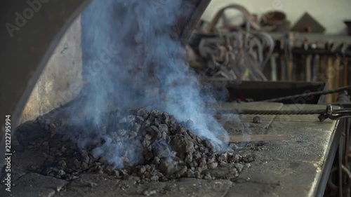 A Close-Up Look at the Process of Blacksmithing with Glowing Forge and Billowing Smoke Rising from the Anvil, Showcasing the Artistry and Techniques of Metalworking