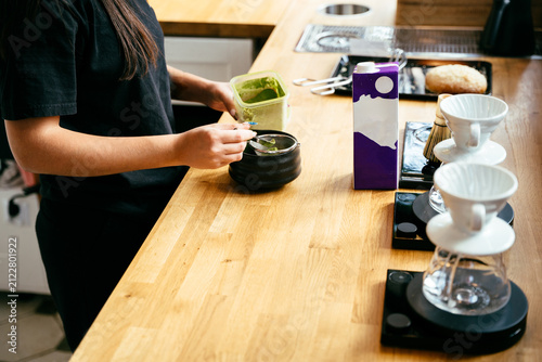 Принти на полотні Focused barista preparing matcha drink with traditional tools at specialty coffe