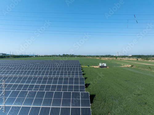 Tapety artystyczne Rows of solar panels in a green field under blue sky