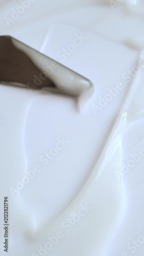 Creamy cosmetic texture spreading with spatula for skincare and beauty product demonstration