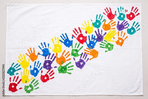 Diagonal pattern of colorful handprints painted across a white fabric banner, symbolizing creativity, teamwork, and diversity. Clean studio shot with copy space for education, events, and branding.