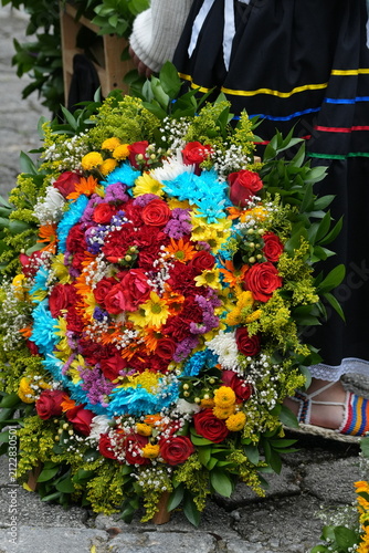 Traditional Handcrafted Flower Silleta Arrangement with Vibrant Roses and Chrysanthemums Displayed by Silletera in Cultural Costume during Medellin Flower Festival