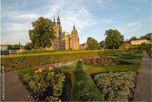 Rosenborg Castle glowing through lush park greenery in early summer morning