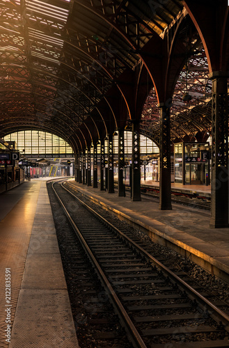 Morning sun streaming across Copenhagen Central Station tracks in summer dawn