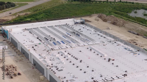 Aerial view of a large data center facility under construction featuring a white roof and surrounding industrial landscape