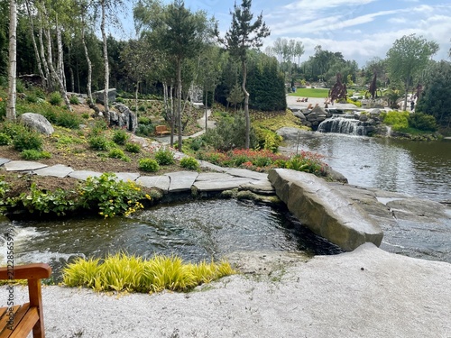 A rock bridge over a river in a botanical garden
