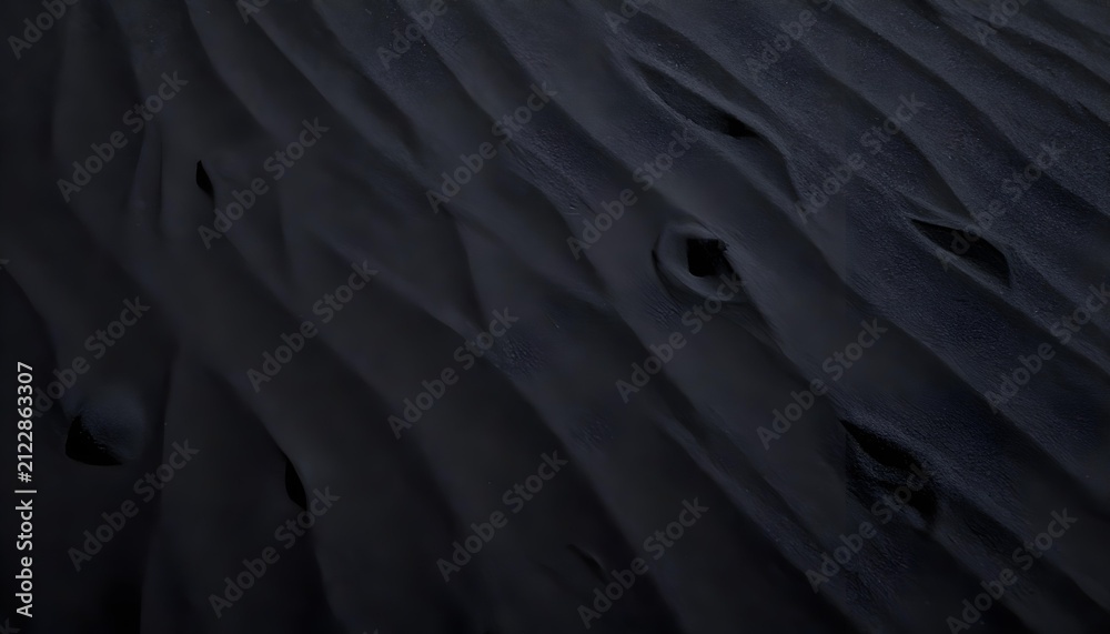 Obraz premium Close-up high-angle shot captures the texture of dark sand dunes