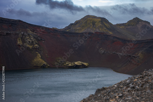 Foto Volcanic crater lake with moss-covered mountains in Iceland