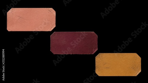 Three worn blank paper labels isolated on black background