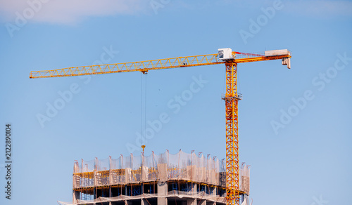 Obraz na plátne Construction crane towering over building under blue sky in Astana, Kazakhstan