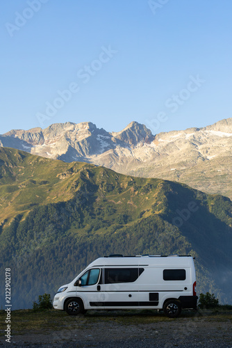 Camper van exploring Pyrenees mountains at sunrise
