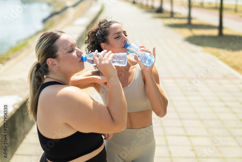 Картината върху платно Diverse women hydrating outdoors after fitness training