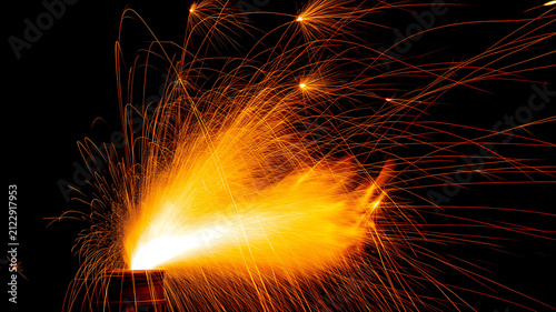 Bild auf Leinwand Bright molten metal sparks spraying at night with grinding industry industrial w