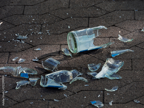 Broken Glass Bottle on Pavement with Shattered Pieces