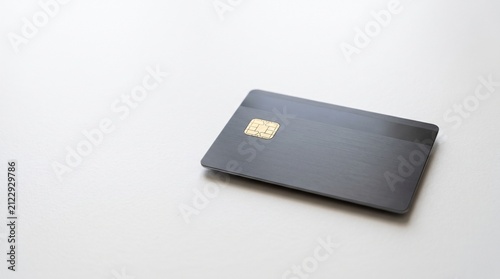 Modern dark gray credit card with gold chip on a clean white background with copy space