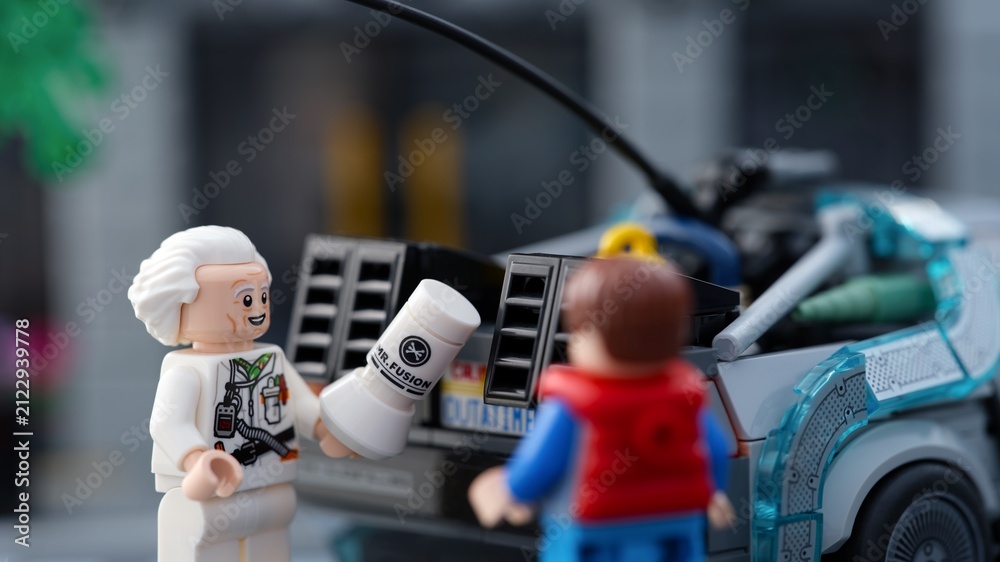 Fototapeta premium Tambov, Russian Federation - July 30, 2026 A close-up shot of a Lego Doc Brown minifigure holding a Mr. Fusion generator next to Marty McFly and the DeLorean time machine.