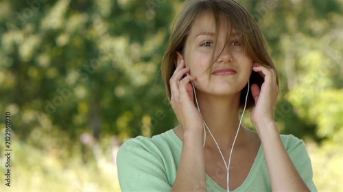 Young woman listening to music through headphones