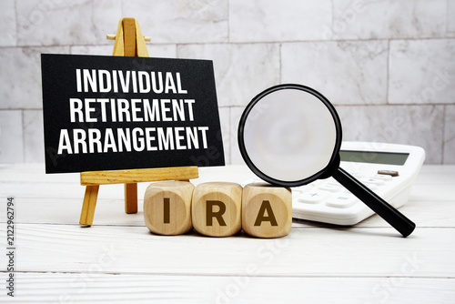 Foto IRA Individual Retirement Arrangement text with calculator magnifying glass and