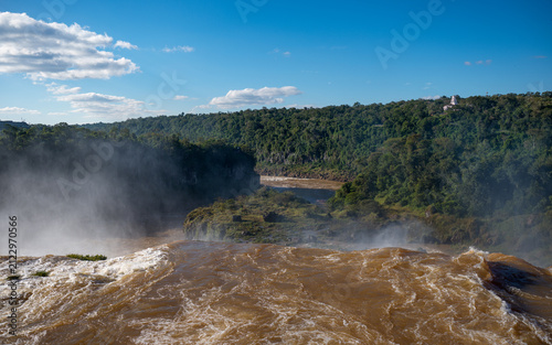 Bild auf Leinwand View Downstream from the Brink of Iguazu Falls into a Forested River Gorge