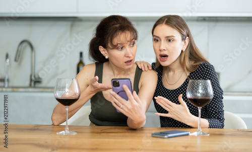 Canvastavla Dreary middle-aged women sitting at kitchen-table with resentful expression in t