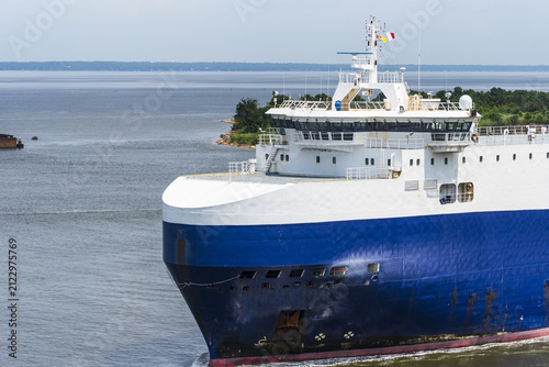 Close-up of a modern Ro-Ro cargo ship underway toward its berth in Mobile, Alabama, with a clean white superstructure and blue hull.