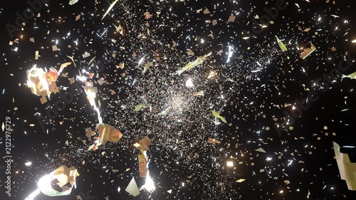 3d animation of a glowing gold cloth flying through dark space shredding,  tearing into countless beautiful gold confetti particles camera moving forward falling sparkles 3D render 10bit alpha.