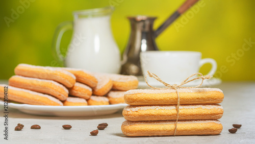 Italian savoiardi cookies or ladybugs cookies on a plate and tied with a rope, a jug of milk in the background. Selective focus