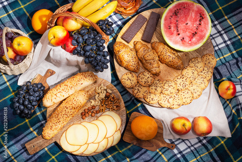 View of different food for summer picnic on checkered blanket, flat lay. The concept of summer outdoor recreation on the weekend